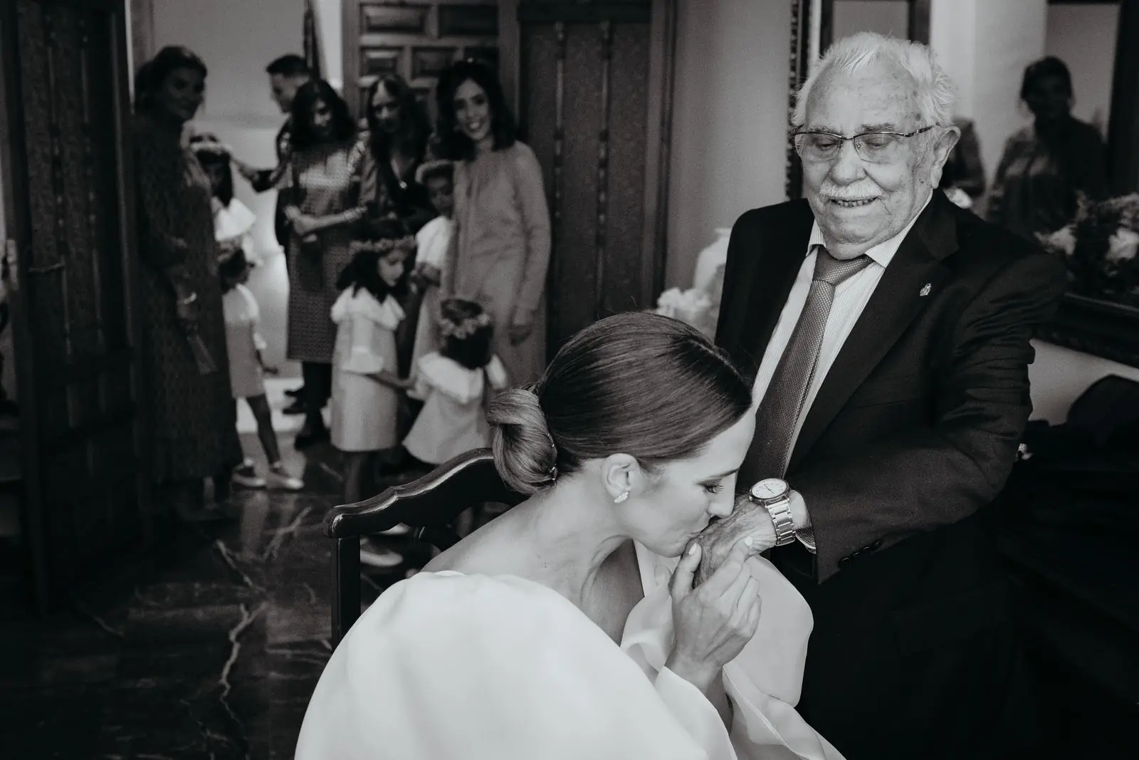 La novia besa la mano de su abuelo el día de la boda