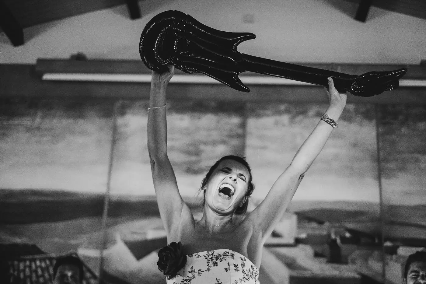 Una invitada levantando una guitarra hinchable en plena fiesta