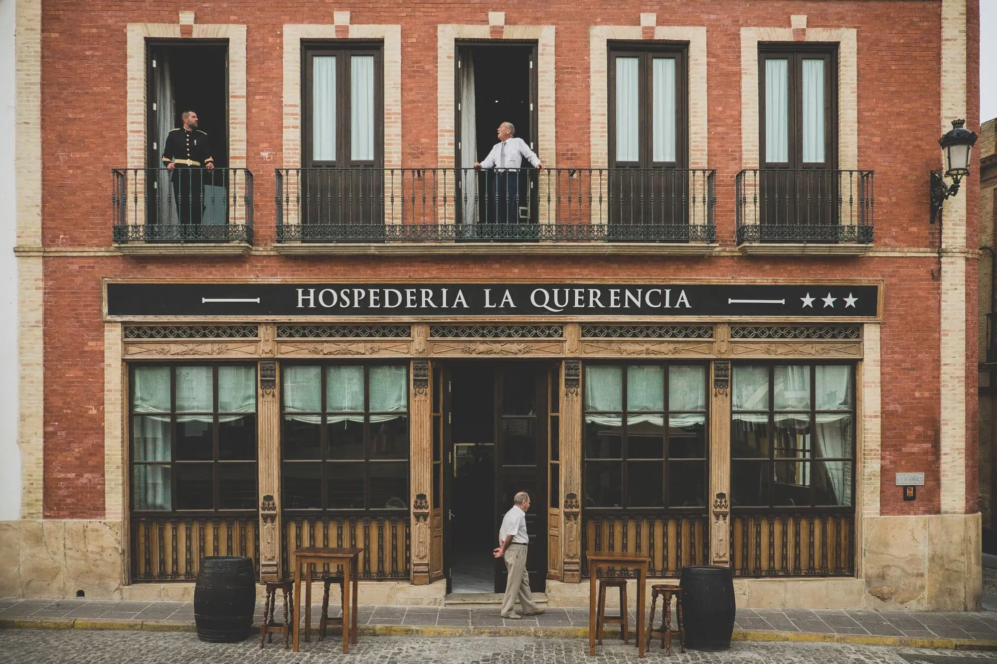 El novio y su padre asomados a los balcones de la hospedería antes de la boda